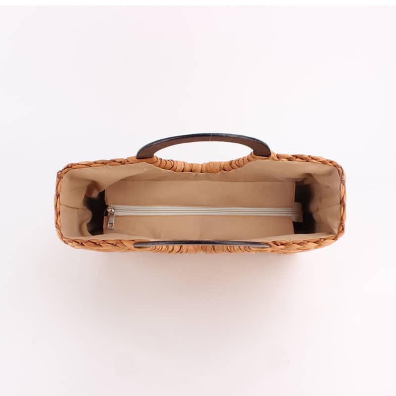 Vintage brown rattan bag with round wooden handles – close-up detail