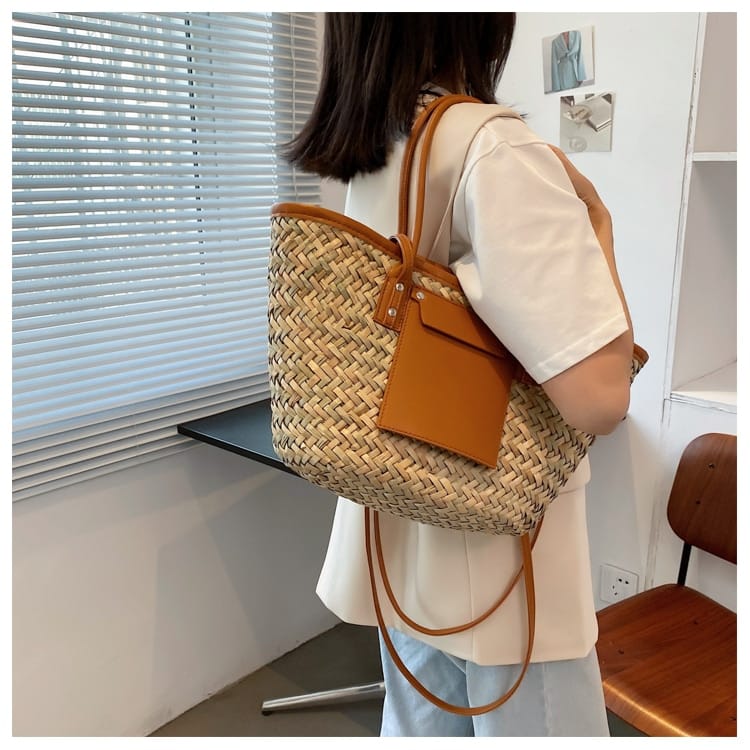 Brown rattan beach tote with a leather handle – worn by a model