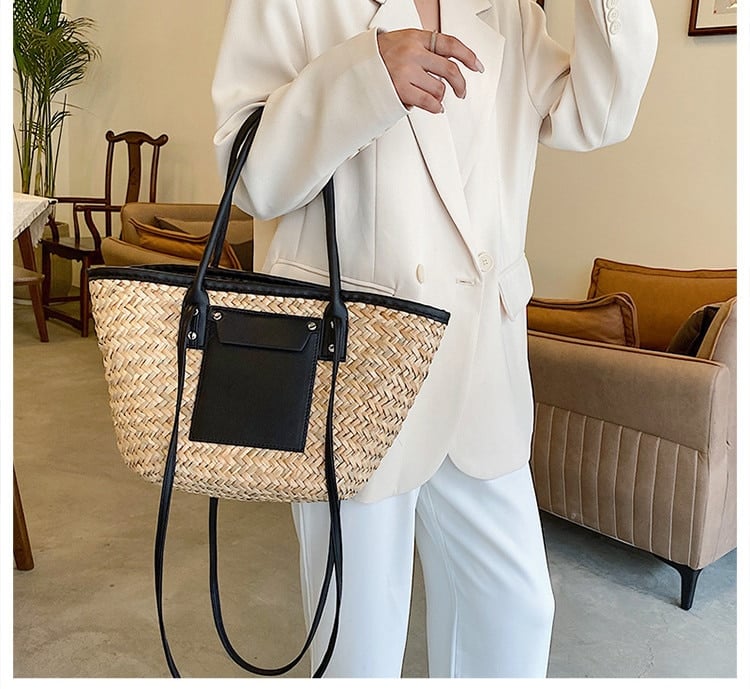 Compact rattan bag with black leather handles – worn by a model (2)