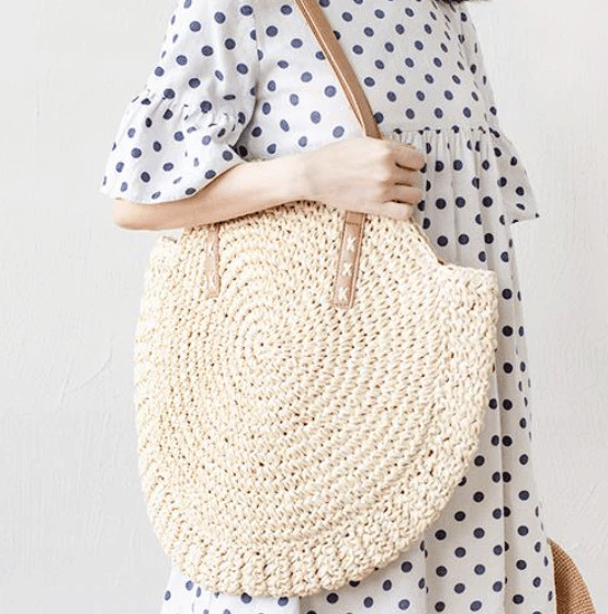 Golden beige woven beach bag – worn by a model