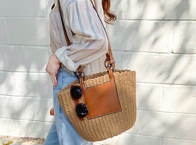Large straw crossbody bag with a natural-tone strap – worn by a model