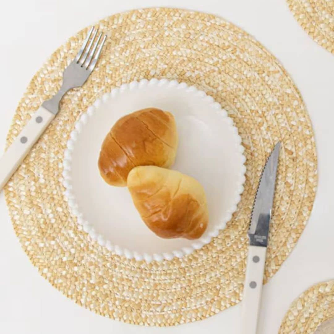 Round non-slip woven placemat in a sand color – shown in a room setting (2)