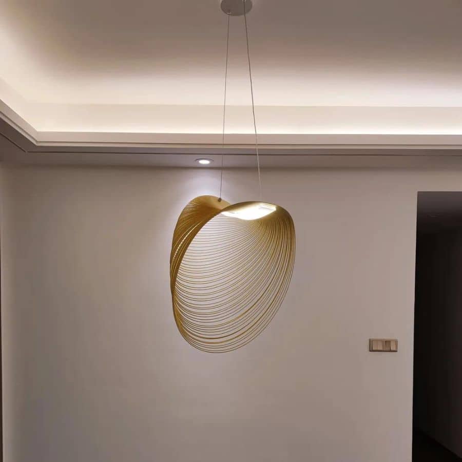 Futuristic geometric wood blade pendant light – shown lit in a room setting