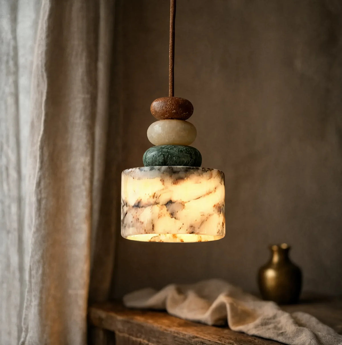 Agrigente stacked stone and marble pendant light – shown lit in a room setting (2)