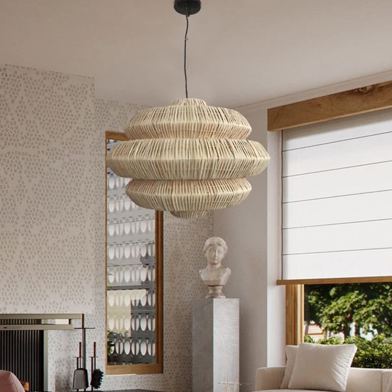 Open rattan pendant light with a central knot detail – beige variant, shown in a room setting