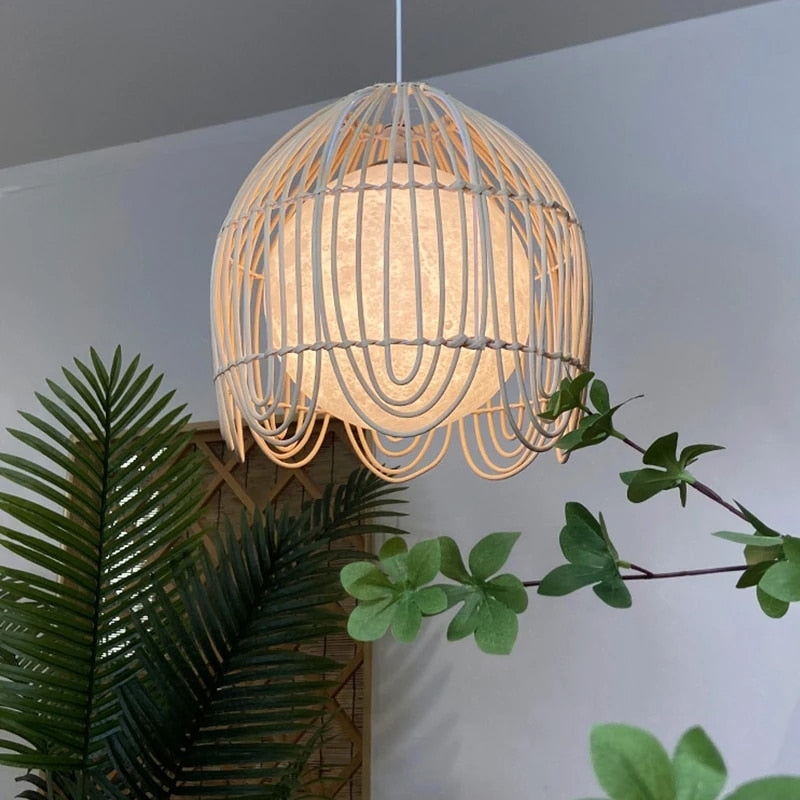 Geometric handwoven rattan, bamboo and wicker pendant light – shown lit in a room setting