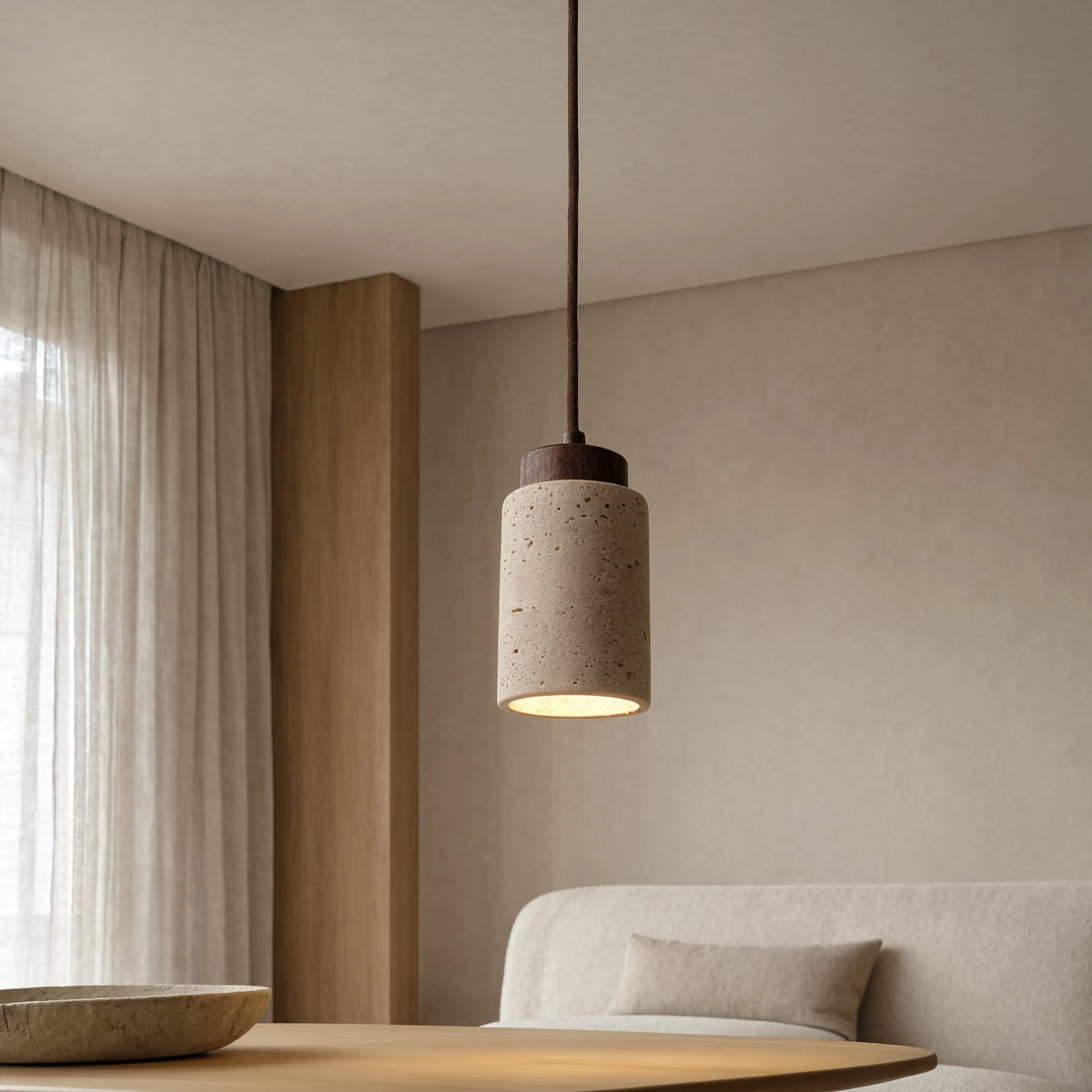 Paestum travertine cylinder pendant light with dark wood cap – shown in a living room (2)