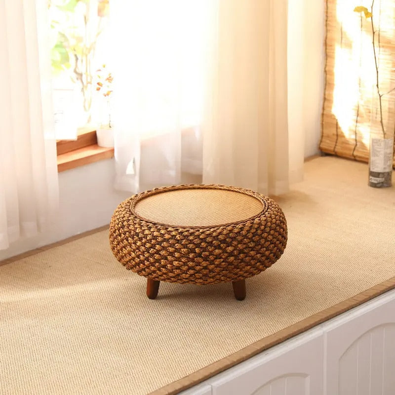 Round handwoven wicker coffee table with an interwoven base – shown in a room setting