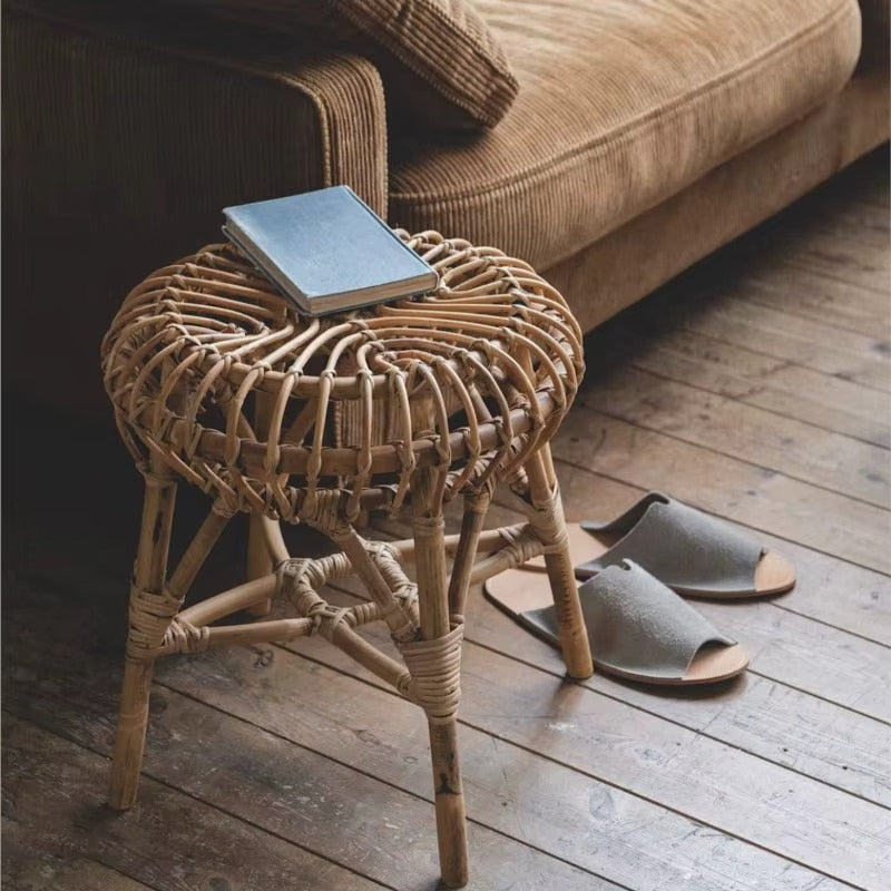 Round Scandinavian wicker stool with slender tapered legs – shown in a room setting