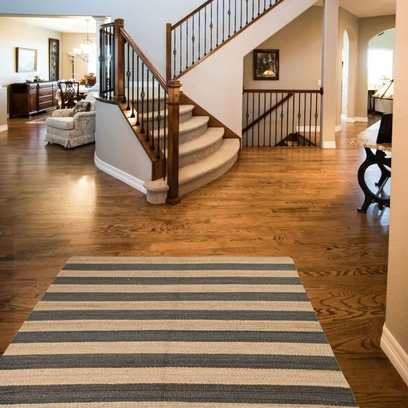 Striped rectangular handwoven wicker rug – shown in a room setting