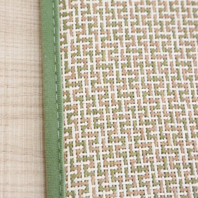 Rectangular synthetic rattan rug with a green border – close-up detail