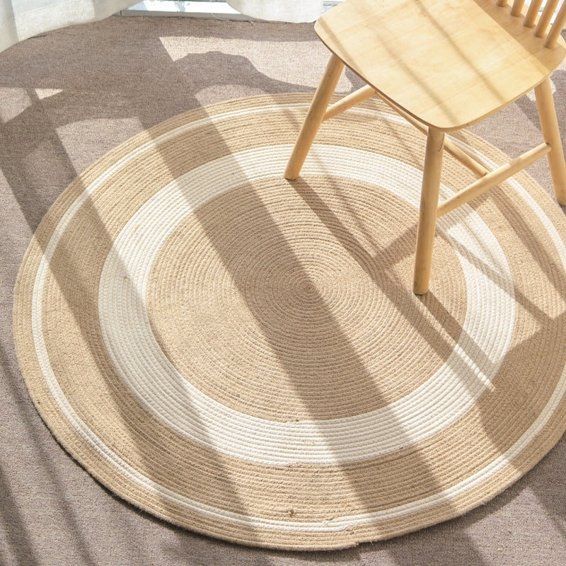 Round natural jute rug with a golden tone – shown in a room setting (2)
