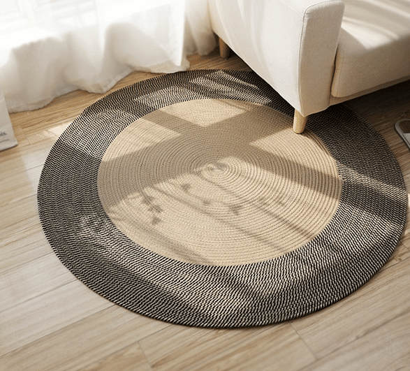 Round black and natural jute rug with a geometric pattern – shown in a room setting (2)