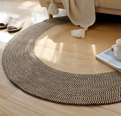 Round black and natural jute rug with a geometric pattern – shown in a room setting