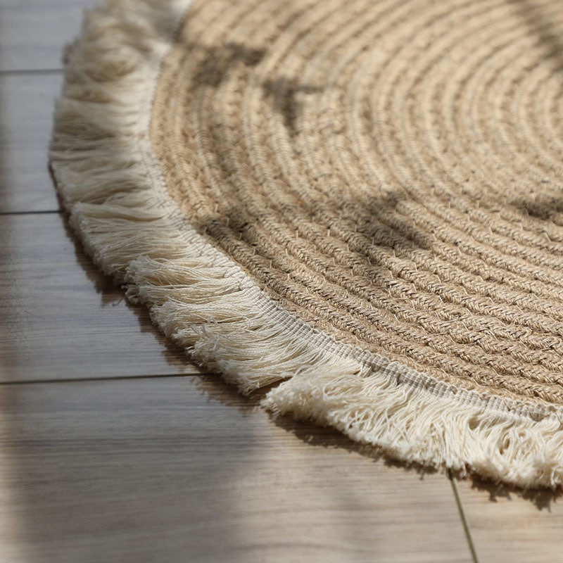 Round handmade cotton and linen rug with a pom-pom fringe – close-up detail
